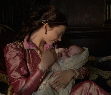 A still from The Tudors series showing Natalie Dormer as Anne Boleyn with baby Elizabeth in her arms